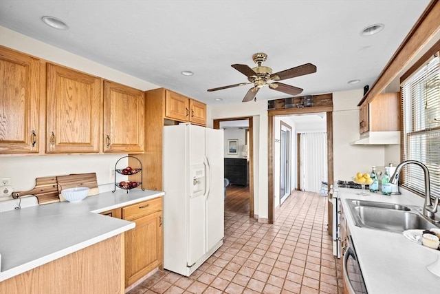 kitchen with white refrigerator with ice dispenser, a ceiling fan, dishwashing machine, light countertops, and a sink