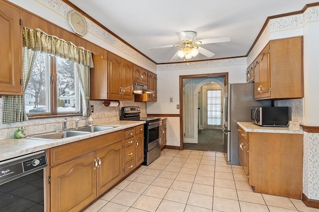 kitchen featuring light countertops, appliances with stainless steel finishes, a sink, and under cabinet range hood