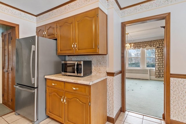 kitchen with stainless steel appliances, crown molding, radiator heating unit, and wallpapered walls