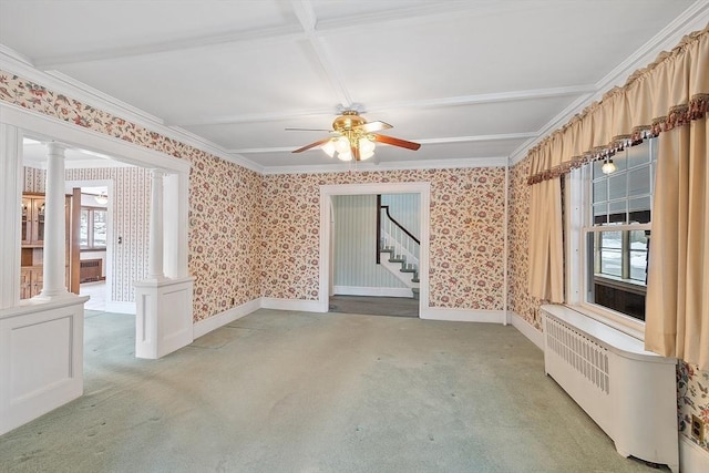 spare room featuring radiator heating unit, light carpet, ornate columns, and wallpapered walls