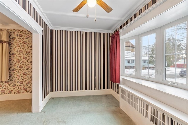 empty room with baseboards, radiator, wallpapered walls, carpet, and crown molding