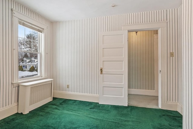 spare room with radiator, wallpapered walls, baseboards, and carpet floors