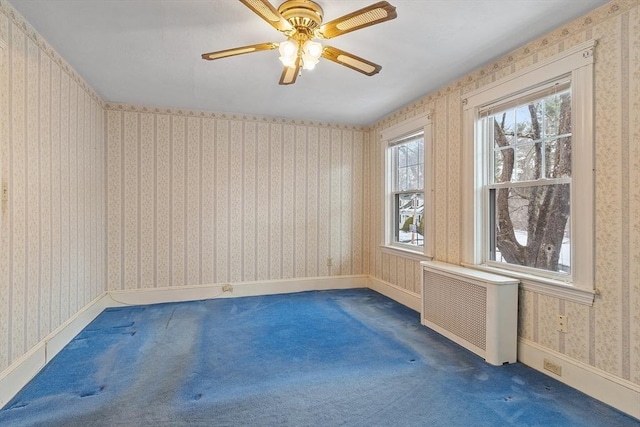 spare room with carpet floors, wallpapered walls, radiator heating unit, and baseboards