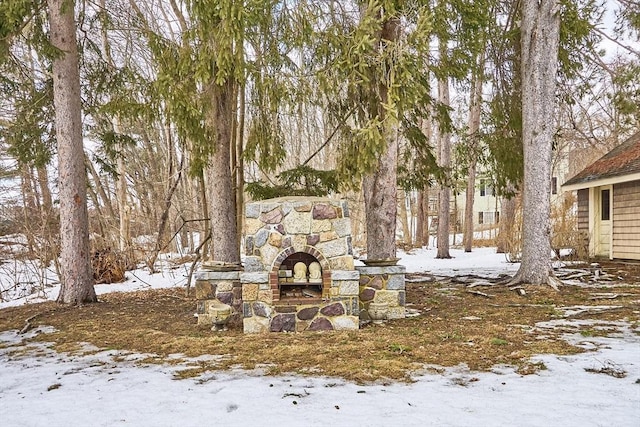 yard covered in snow with exterior fireplace