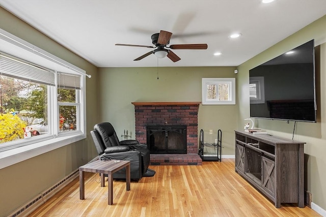 92 Hilltop Rd, Whitman, MA 02382 - living area with a ceiling fan, light wood-style floors, baseboards, a baseboard radiator, and a brick fireplace