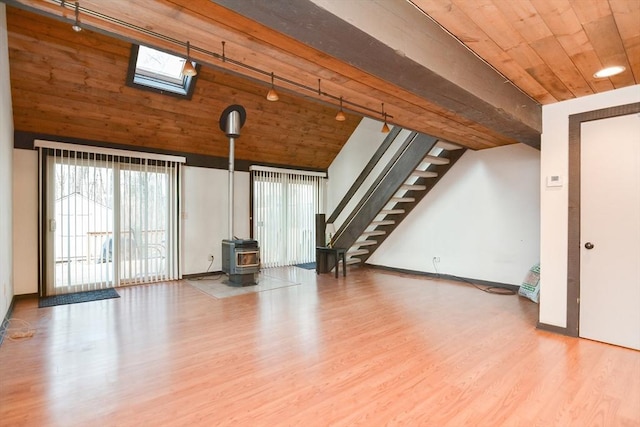 unfurnished living room with track lighting, a skylight, hardwood / wood-style flooring, wooden ceiling, and a wood stove