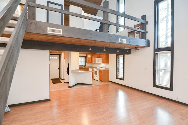 unfurnished living room with a high ceiling and light hardwood / wood-style flooring