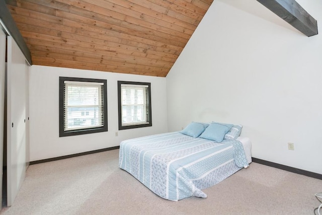 bedroom with vaulted ceiling with beams, light colored carpet, a closet, and wood ceiling