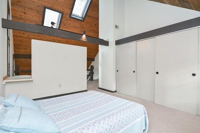 bedroom with light carpet, a skylight, high vaulted ceiling, and a closet