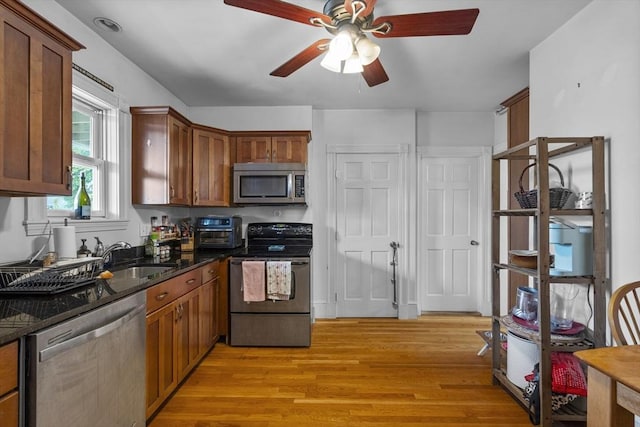 733 E 3rd St, Boston, MA 02127 - kitchen featuring appliances with stainless steel finishes, ceiling fan, light wood-type flooring, a sink, and dark stone countertops