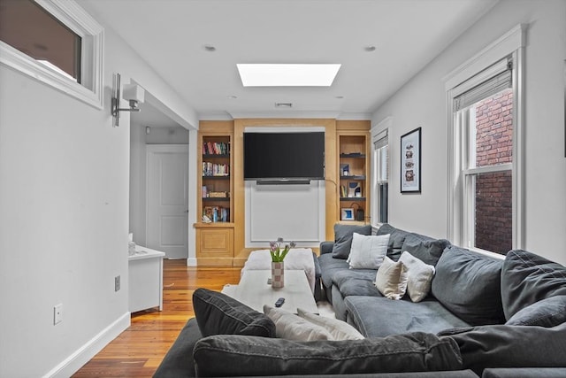 733 E 3rd St, Boston, MA 02127 - living room with a skylight, wood finished floors, and baseboards