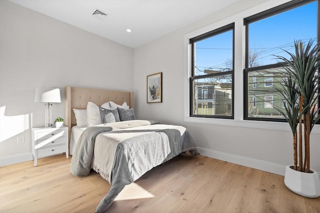 bedroom featuring light wood-style floors, recessed lighting, visible vents, and baseboards