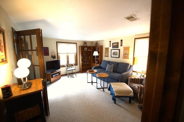 carpeted living room with a healthy amount of sunlight and visible vents