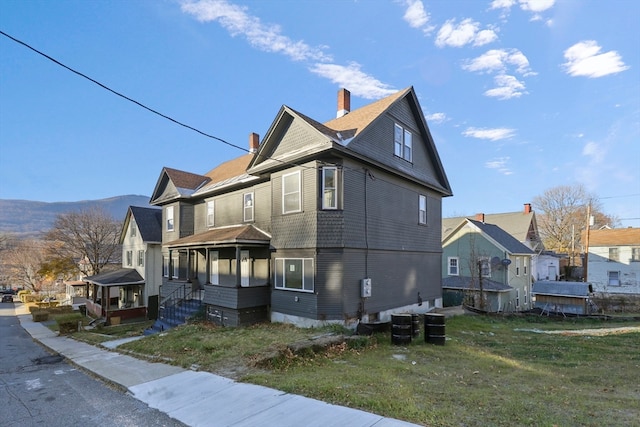 view of property exterior with a porch and a lawn