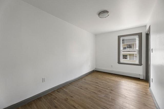 spare room with hardwood / wood-style floors and baseboard heating