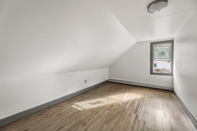 bonus room featuring light hardwood / wood-style floors, lofted ceiling, and a baseboard heating unit