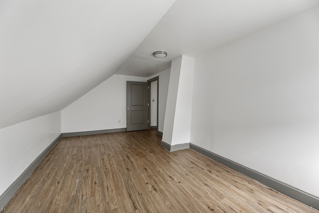 bonus room featuring light hardwood / wood-style flooring and vaulted ceiling