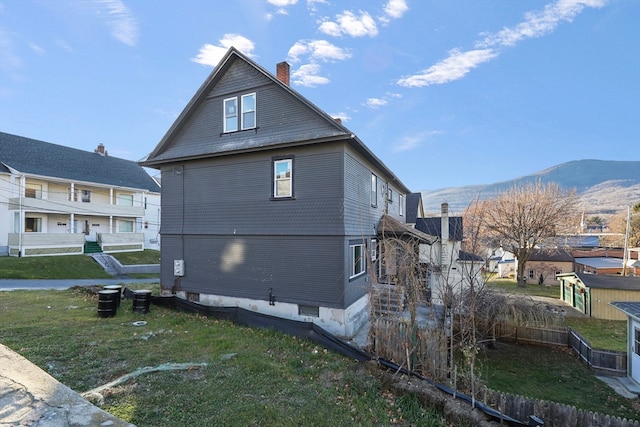 view of home's exterior featuring a mountain view and a yard