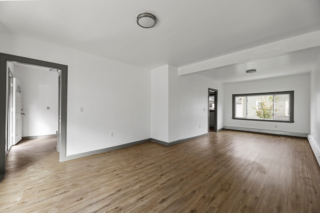 spare room with hardwood / wood-style floors and baseboard heating