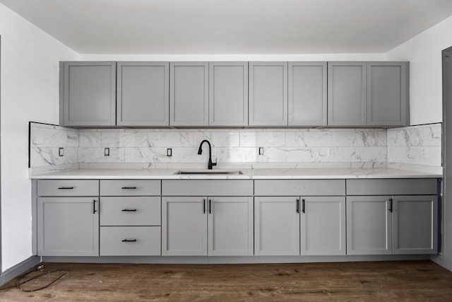 kitchen featuring backsplash, dark hardwood / wood-style floors, gray cabinets, and sink