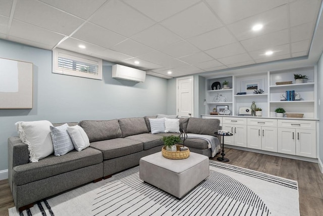 10 Morse Rd, Wayland, MA 01778 - living room featuring wood finished floors, a wall mounted AC, built in shelves, a paneled ceiling, and recessed lighting