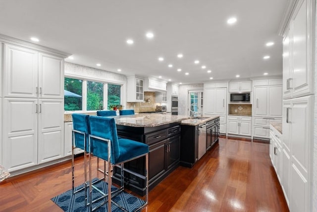 1 Croftdale, Newton, MA 02459 - kitchen with appliances with stainless steel finishes, white cabinets, tasteful backsplash, light stone countertops, and a kitchen island with sink