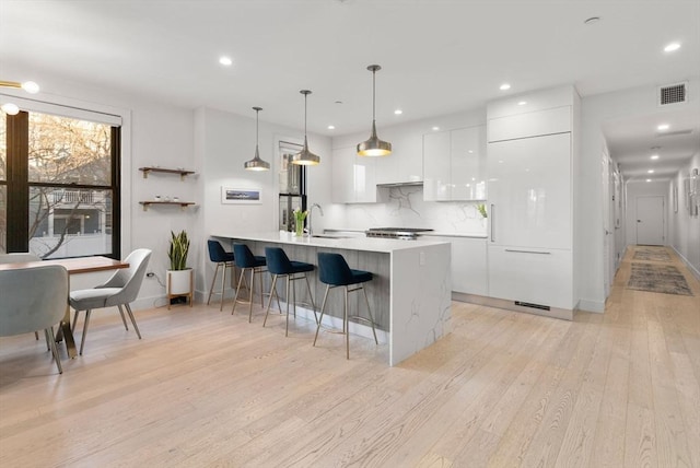 kitchen with visible vents, white cabinets, modern cabinets, light countertops, and pendant lighting