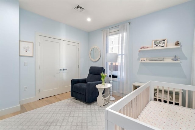 bedroom featuring baseboards, visible vents, wood finished floors, a closet, and recessed lighting