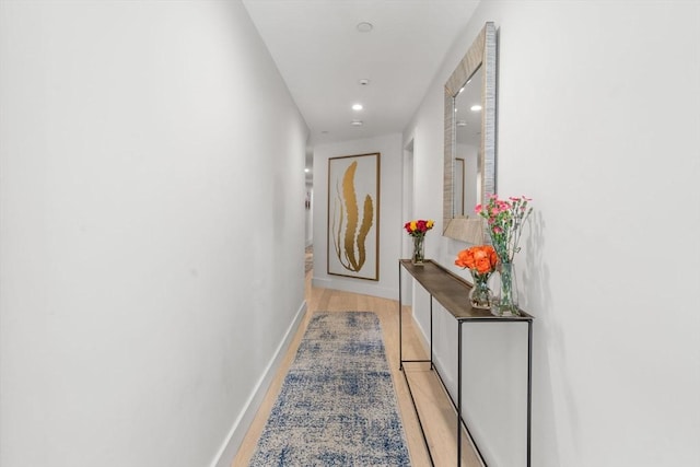 corridor with recessed lighting, light wood finished floors, and baseboards