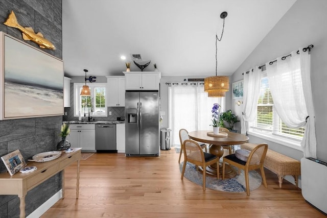 2 Jason Ter, Fairhaven, MA 02719 - kitchen with stainless steel appliances, vaulted ceiling, light wood-style flooring, tasteful backsplash, and white cabinetry