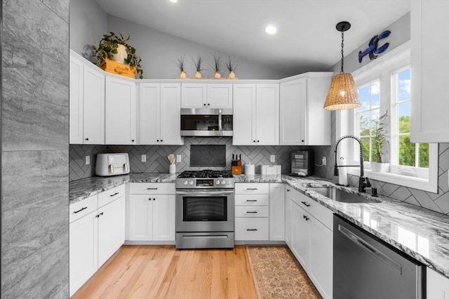 2 Jason Ter, Fairhaven, MA 02719 - kitchen featuring appliances with stainless steel finishes, a sink, vaulted ceiling, backsplash, and light wood-type flooring