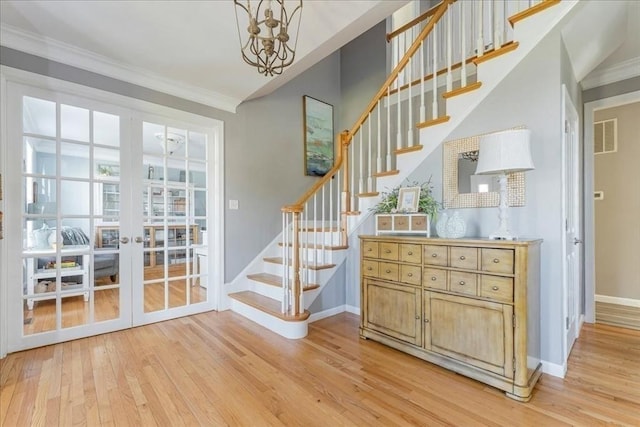 33 Freeman Dr, Plymouth, MA 02360 - staircase featuring wood finished floors, baseboards, french doors, ornamental molding, and a chandelier