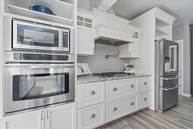 33 Freeman Dr, Plymouth, MA 02360 - kitchen with appliances with stainless steel finishes, white cabinetry, light wood finished floors, light stone countertops, and glass insert cabinets