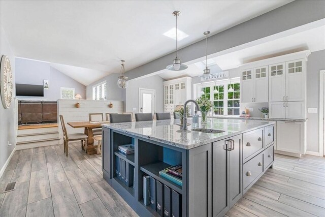33 Freeman Dr, Plymouth, MA 02360 - kitchen with a sink, white cabinetry, open shelves, light wood finished floors, and vaulted ceiling
