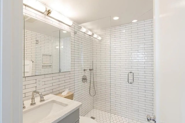 bathroom featuring tasteful backsplash, tile walls, toilet, a shower with shower door, and vanity