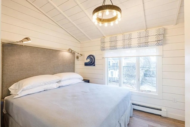 bedroom featuring hardwood / wood-style floors, a baseboard heating unit, and wood walls