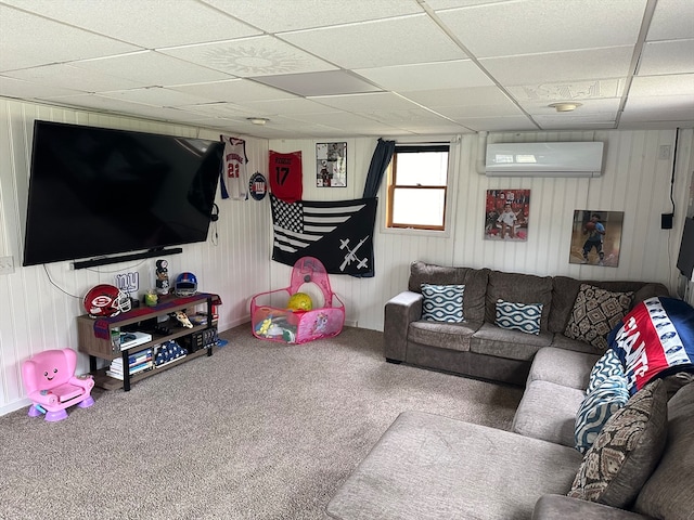 living room with an AC wall unit, a paneled ceiling, wooden walls, and carpet flooring