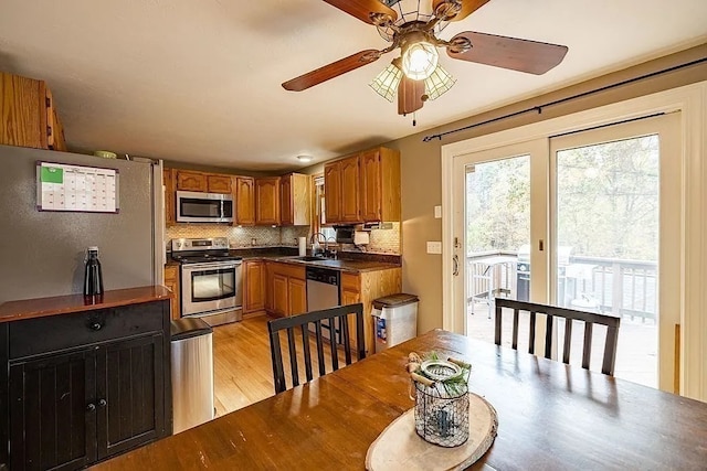 kitchen with ceiling fan, sink, stainless steel appliances, tasteful backsplash, and light hardwood / wood-style floors