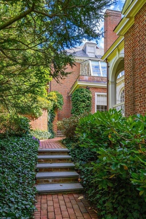 doorway to property with brick siding and a balcony