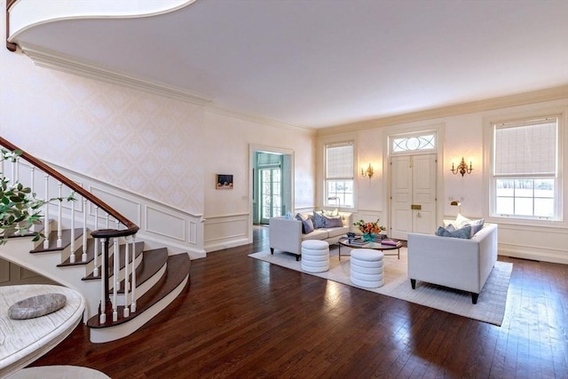 living room featuring a wainscoted wall, stairs, wood-type flooring, crown molding, and a decorative wall