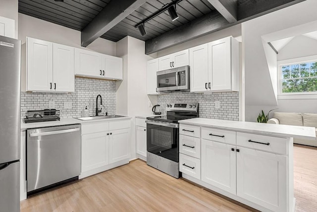 256 Lafayette St Unit 3, Salem, MA 01970 - kitchen with stainless steel appliances, light wood-type flooring, white cabinetry, tasteful backsplash, and a wood ceiling with exposed beams