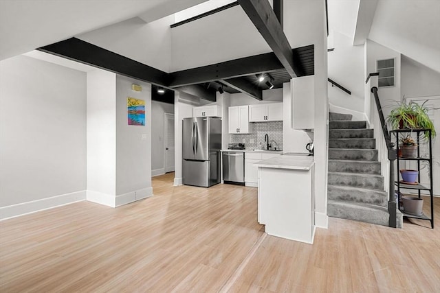 256 Lafayette St Unit 3, Salem, MA 01970 - kitchen featuring stainless steel appliances, white cabinetry, light countertops, tasteful backsplash, and light wood-style flooring
