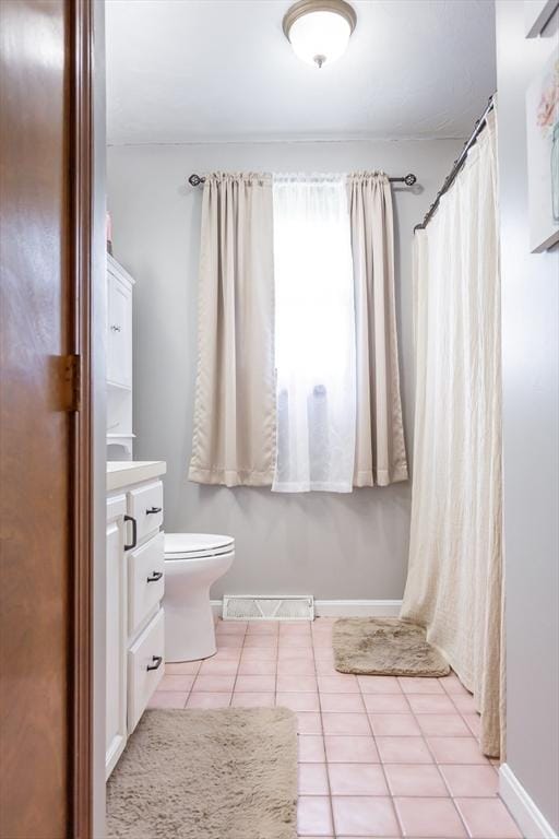 full bath featuring tile patterned flooring, vanity, toilet, and baseboards