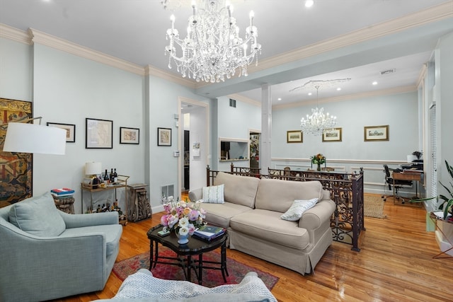 living room featuring an inviting chandelier, light wood-type flooring, and crown molding