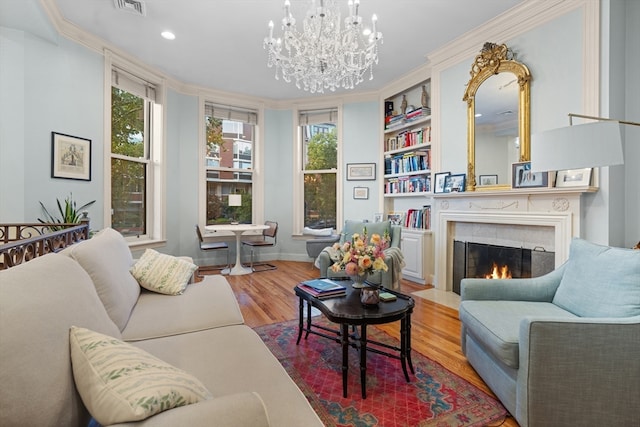 living room featuring an inviting chandelier, crown molding, and hardwood / wood-style floors