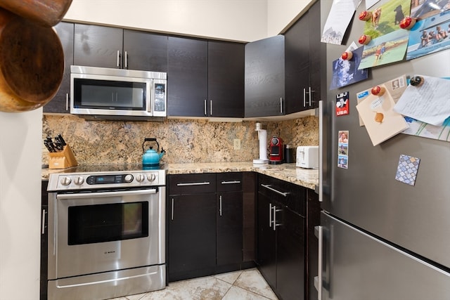 kitchen featuring appliances with stainless steel finishes, decorative backsplash, light stone countertops, and light tile patterned floors