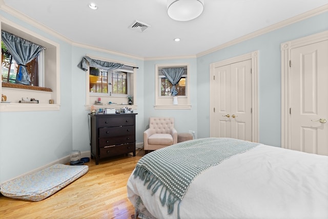 bedroom featuring light wood-type flooring and crown molding