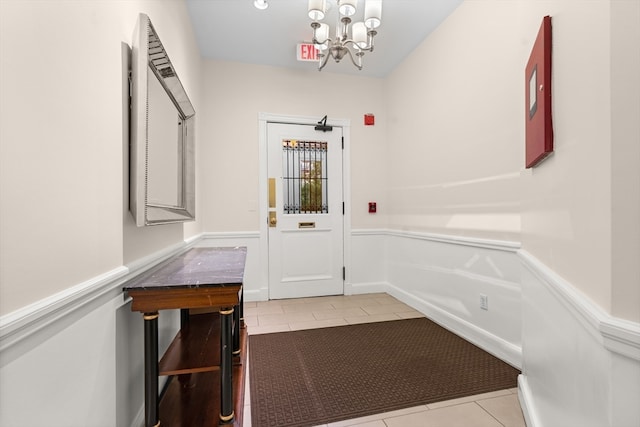 entryway featuring light tile patterned floors and a notable chandelier