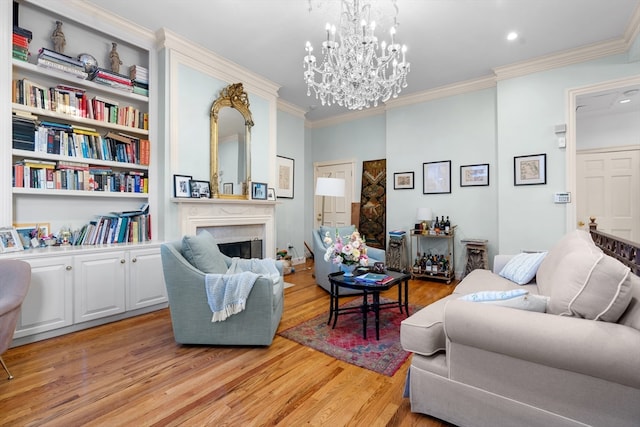 living room featuring light hardwood / wood-style floors, ornamental molding, and a chandelier