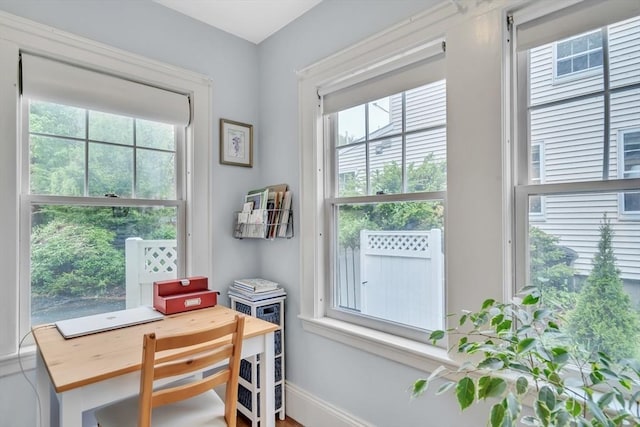 doorway to outside featuring an office area and baseboards